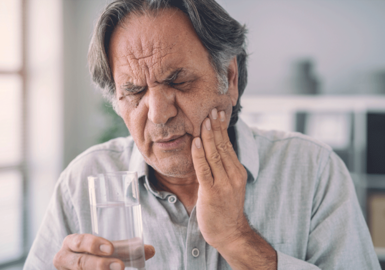 Older man grabbing his cheek in pain